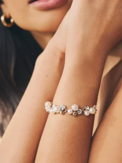 Goudkleurig - Doorgetrokken armband met pareleffect en glitters